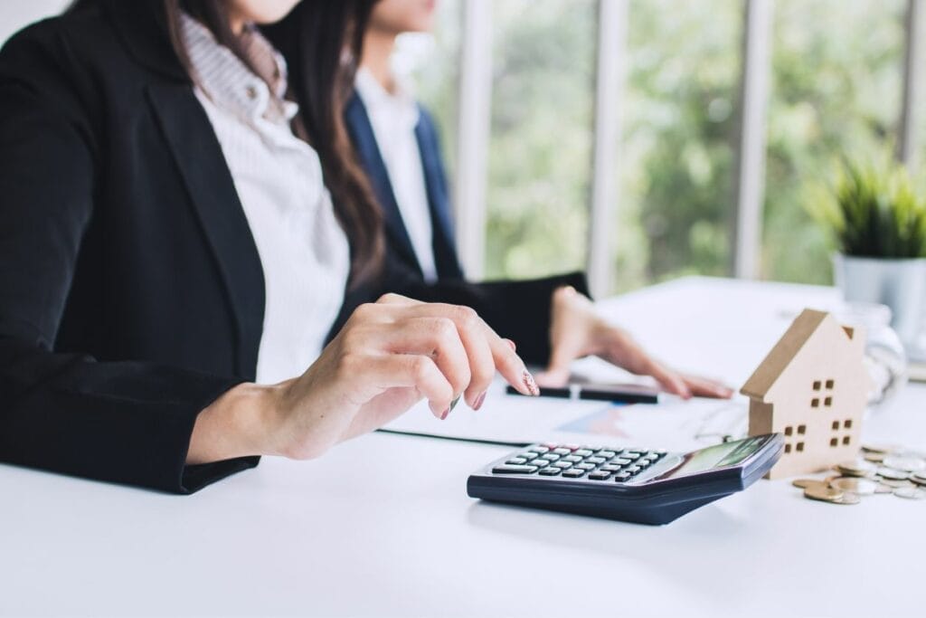 Commercial real estate tax professional on a calculator helping her client navigate complexities of taxes