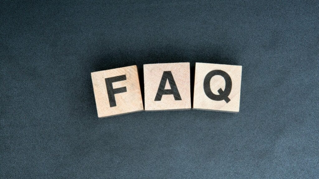 Wooden blocks on a dark background spelling out 'FAQ,' symbolizing frequently asked questions about commercial property management cost details.
