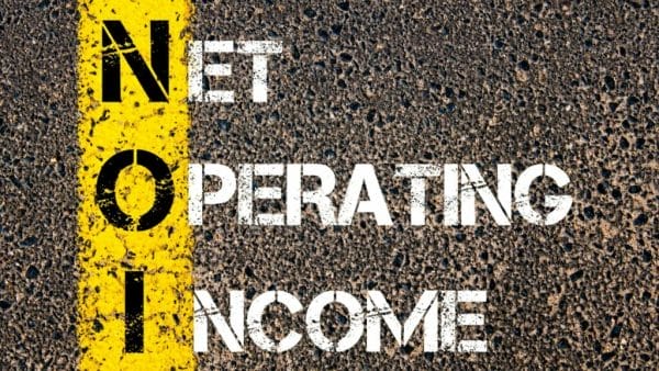 The image features the phrase "NET OPERATING INCOME" stenciled in large white letters across a road surface, with a bold yellow line running through the middle of the text, serving as a metaphorical guide on understanding operational profitability in real estate.