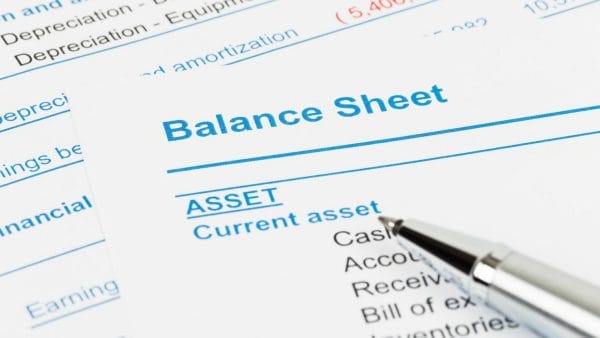 A pen resting on a financial balance sheet highlighting 'Current asset' section, questioning 'is accumulated depreciation an asset'.