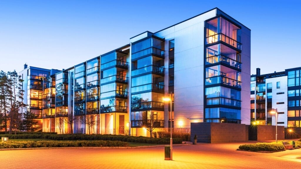 Modern data center building with sleek glass architecture, illuminated at dusk, symbolizing the rising demand for data center commercial real estate investment in the digital economy.